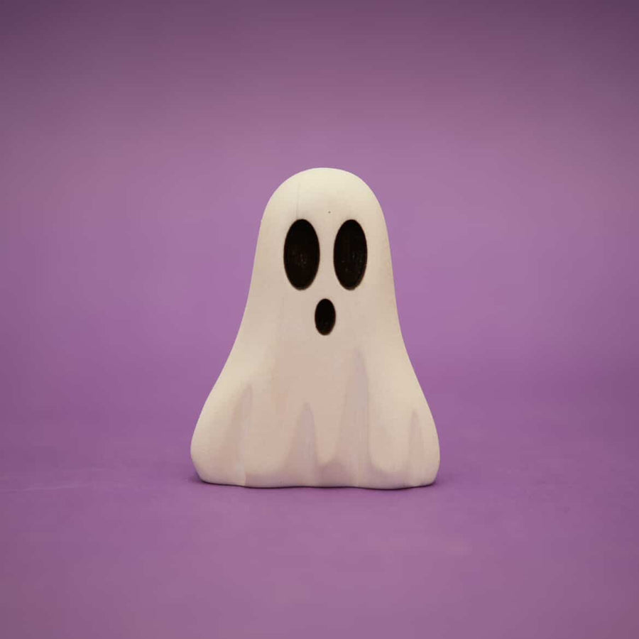 Small wooden ghost painted white with two dark oval eyes and an open mouth