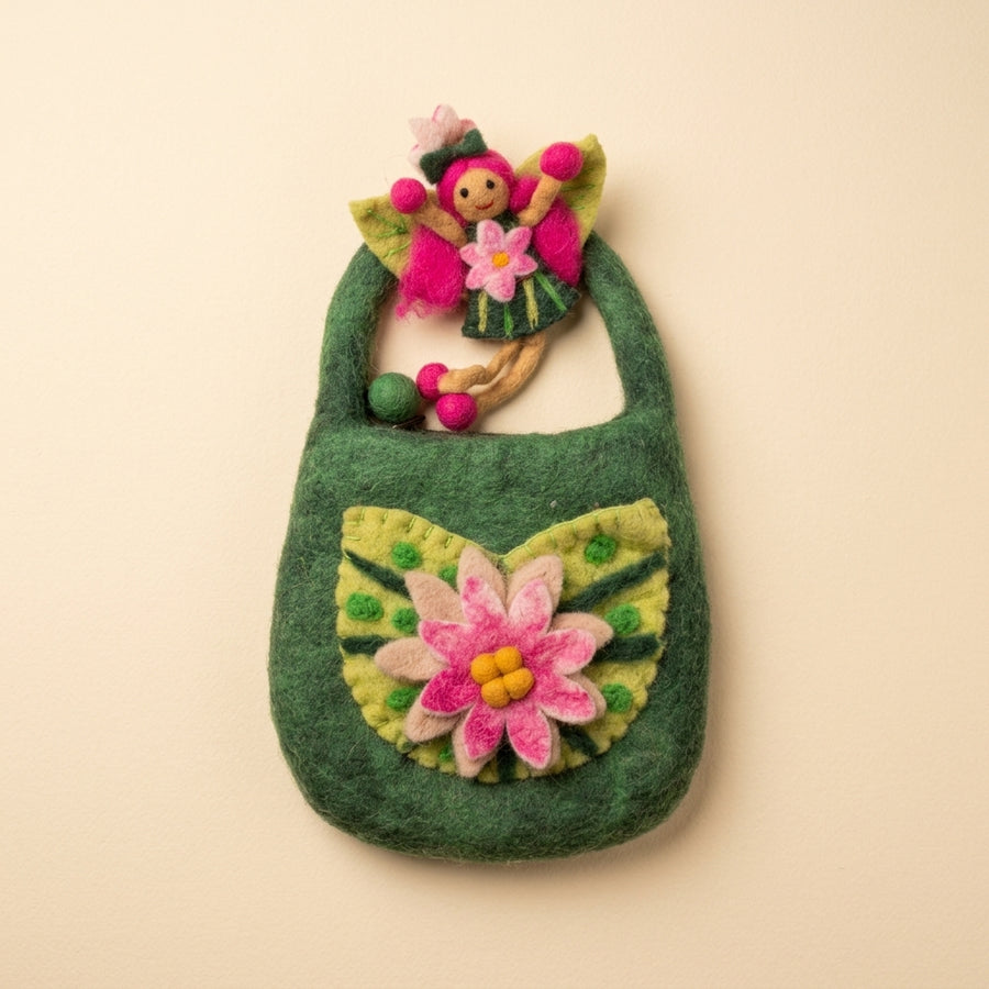 The felt fairy out of the bag, with pink hair, green leaf wings and a green dress with a pink flower