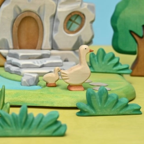 Wooden gosling shown in profile, hand-painted in pale cream and orange