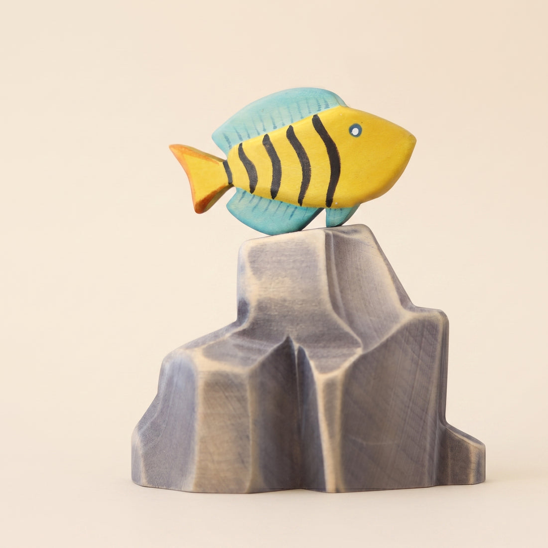 Wooden butterfly fish painted yellow with dark stripes and a blue fin