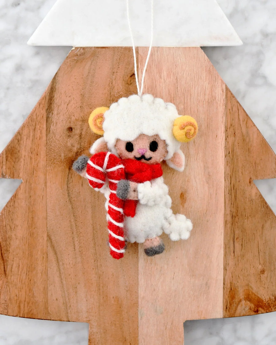 Felt Christmas lamb ornament with golden horns and a red scarf, holding a red and white candy cane