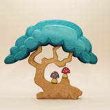 Wooden tree with a deep turquoise canopy, a hollow at the base, and a toadstool beside the roots · view 1