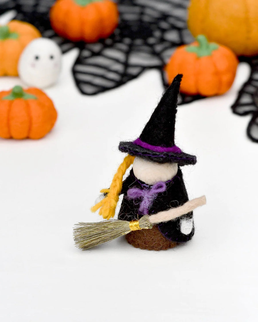 Felt witch peg doll standing beside other Halloween pieces