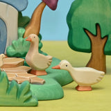 Wooden goose with head up set beside a wooden pond scene · view 3