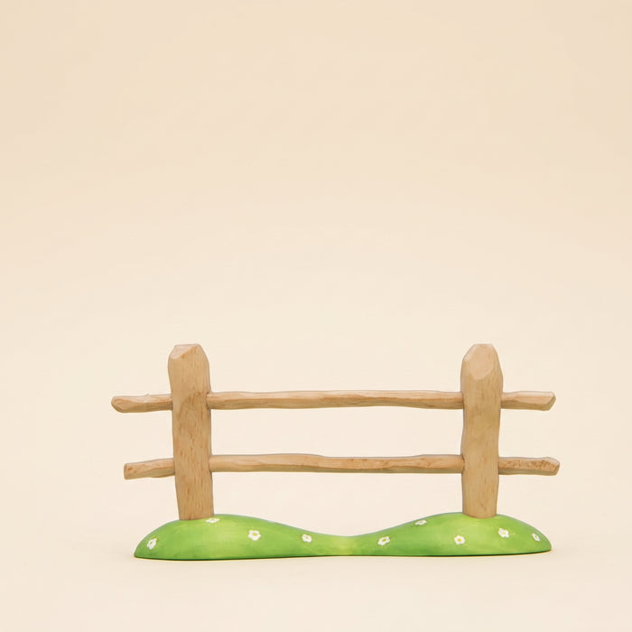 Wooden fence section with two rails on a green painted base