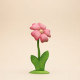 Tall wooden flower with pink layered petals and a yellow center on a green stem and base · view 1