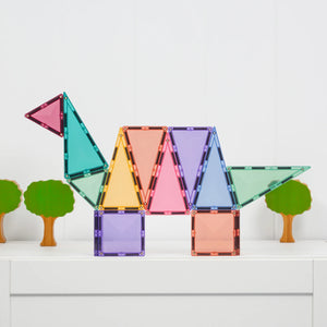 A dinosaur built from Pastel magnetic tiles beside wooden trees