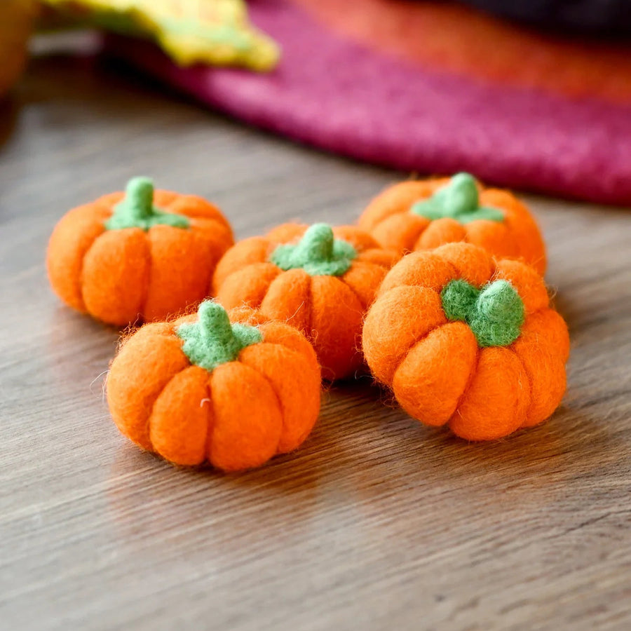 Bright orange felt pumpkins arranged together to show the size of the set