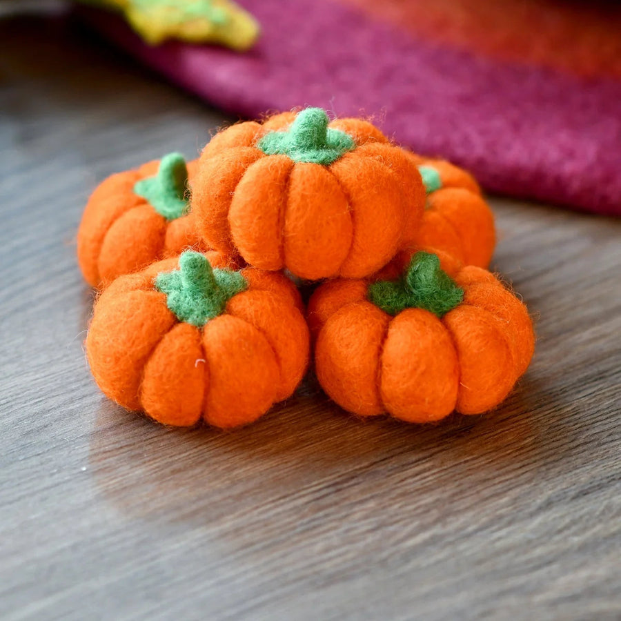 Second view of the bright orange felt pumpkins showing their rounded ribbed shape