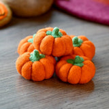 Five small felt pumpkins in bright orange, each with a stitched stem · view 1