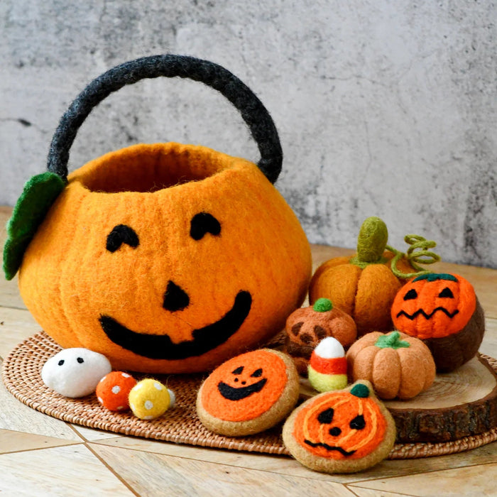 Orange felt jack-o-lantern bag surrounded by felt Halloween food including pumpkins, cookies, and a cupcake