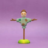 Wooden scarecrow with outstretched arms and a painted shirt, standing on a round base · view 1