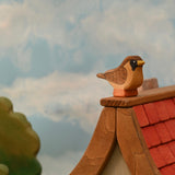 Wooden sparrow figure with a black mask and painted chevron wing markings, standing on a small base · view 2