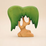 Wooden willow tree with a green canopy hanging down on both sides of a pale forked trunk · view 1